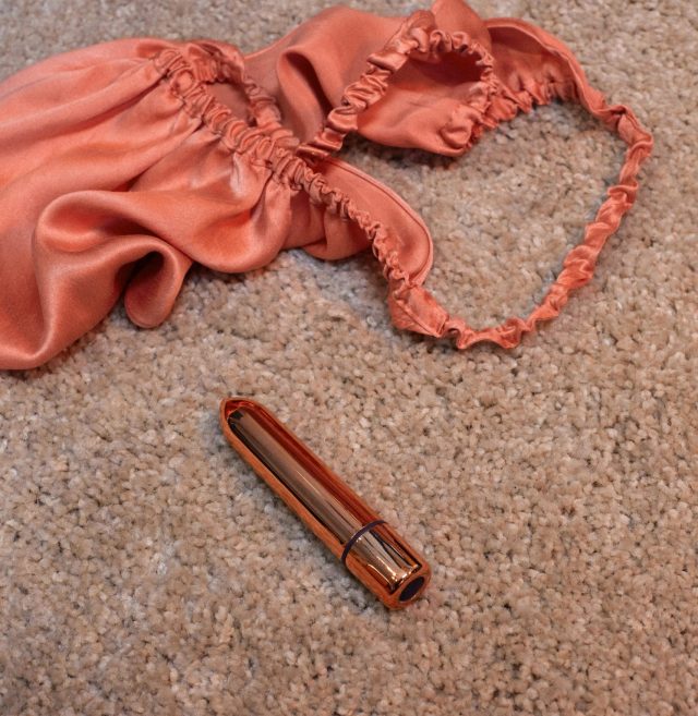 SKYN Thrill sex toy next to a pink nightie