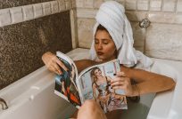 Girl reading a magazine taking a bath